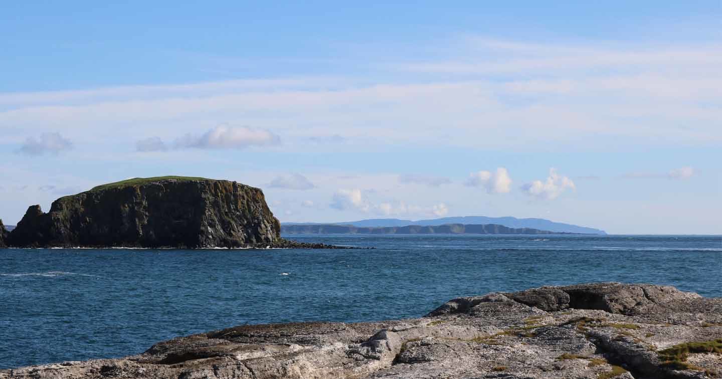 Four sets of coastline as seen across the sea from Ballintoy, Co. Antrim: the beach itself, Sheep Island, Rathlin, and the Mull of Kintyre.