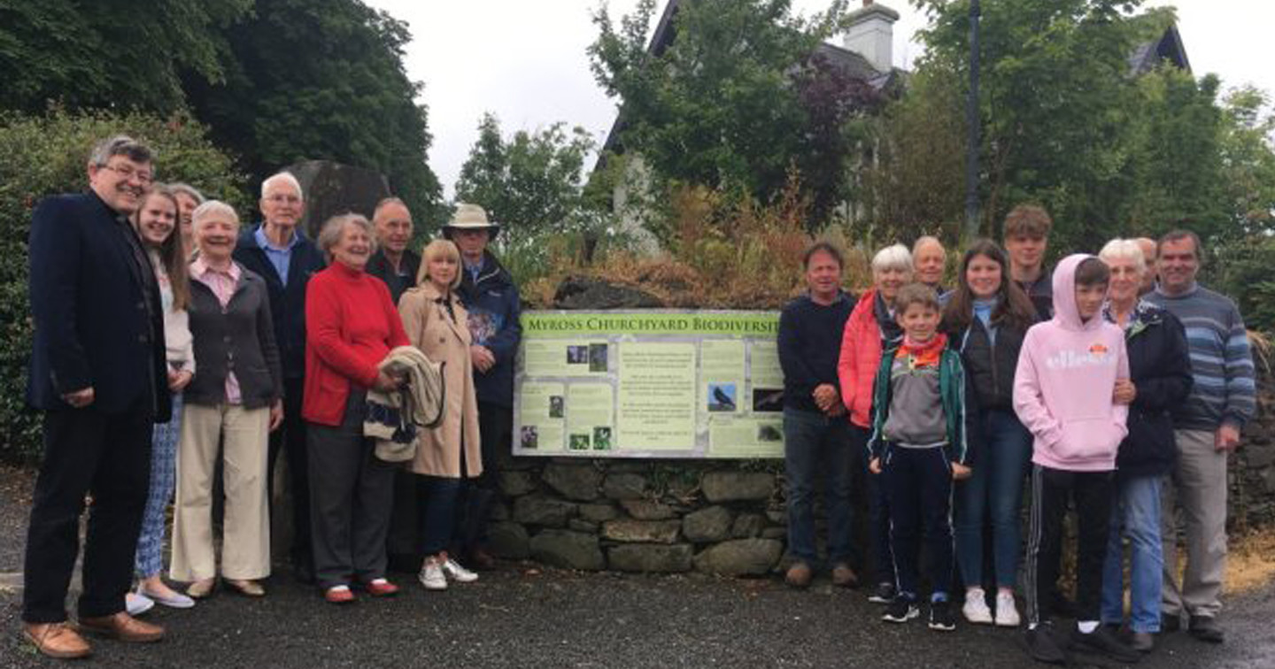 Members of the congregation gathered at the information sign: ‘Myross Churchyard Biodiversity’.