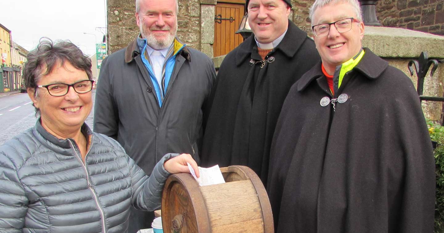 Kate Outram makes a donation as the Revd Charles Eames, Revd John Beacom and Archdeacon Brian Harper sit–out for charity at Magheracross Parish Church, Main Street, Ballinamallard on Wednesday, 20th December.