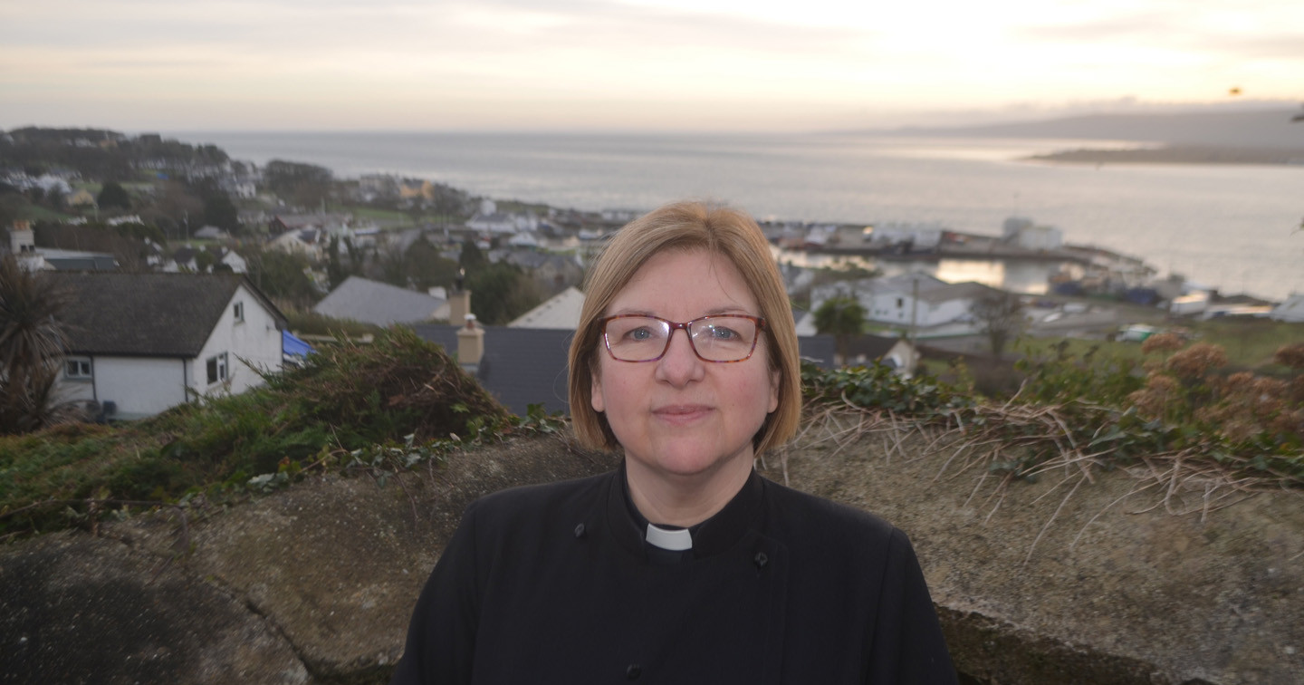 The Rev Suzanne Cousins outside St Finian's Church, which overlooks the fishing port of Greencastle in Donegal