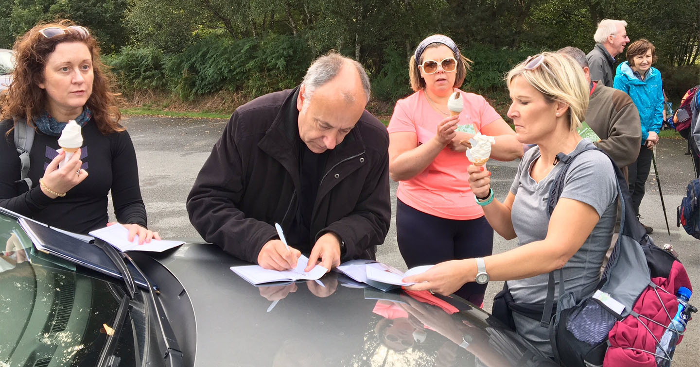 Canon Leonard Ruddock signing the Pilgrim Passports of some of those who took part in the Camino de Glendalough.