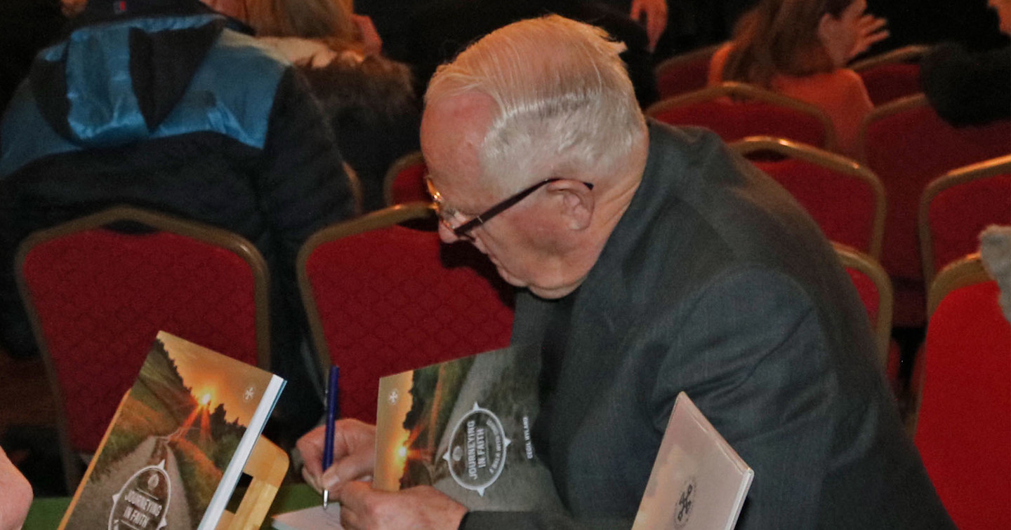 Canon Hyland signs copies of the book.