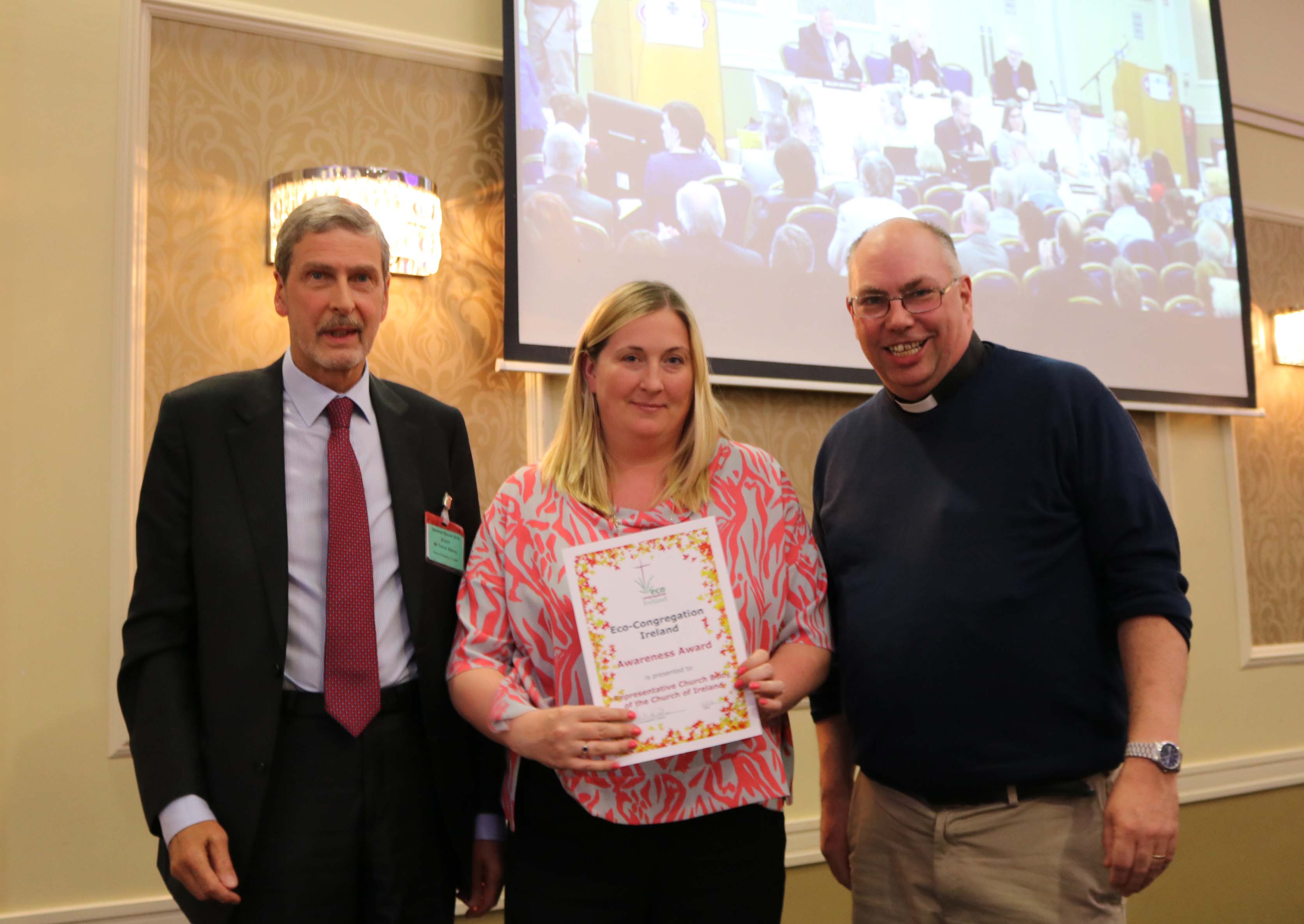 Archdeacon Andrew Orr, Chair of Eco Congregation Ireland, presents an Eco Congregation awareness award to Sarah Dunne, Manager – Investment Portfolio and ESG, and Trevor Stacey, Head of Property, Representative Church Body.