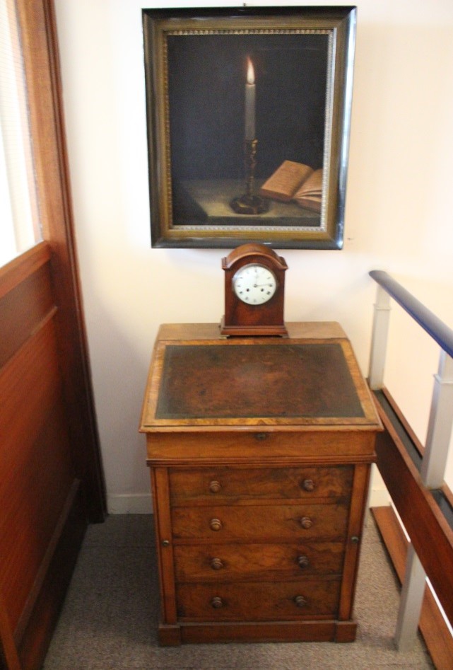 Rosamond Stephen's writing desk, table clock and painting as displayed in the RCB Library