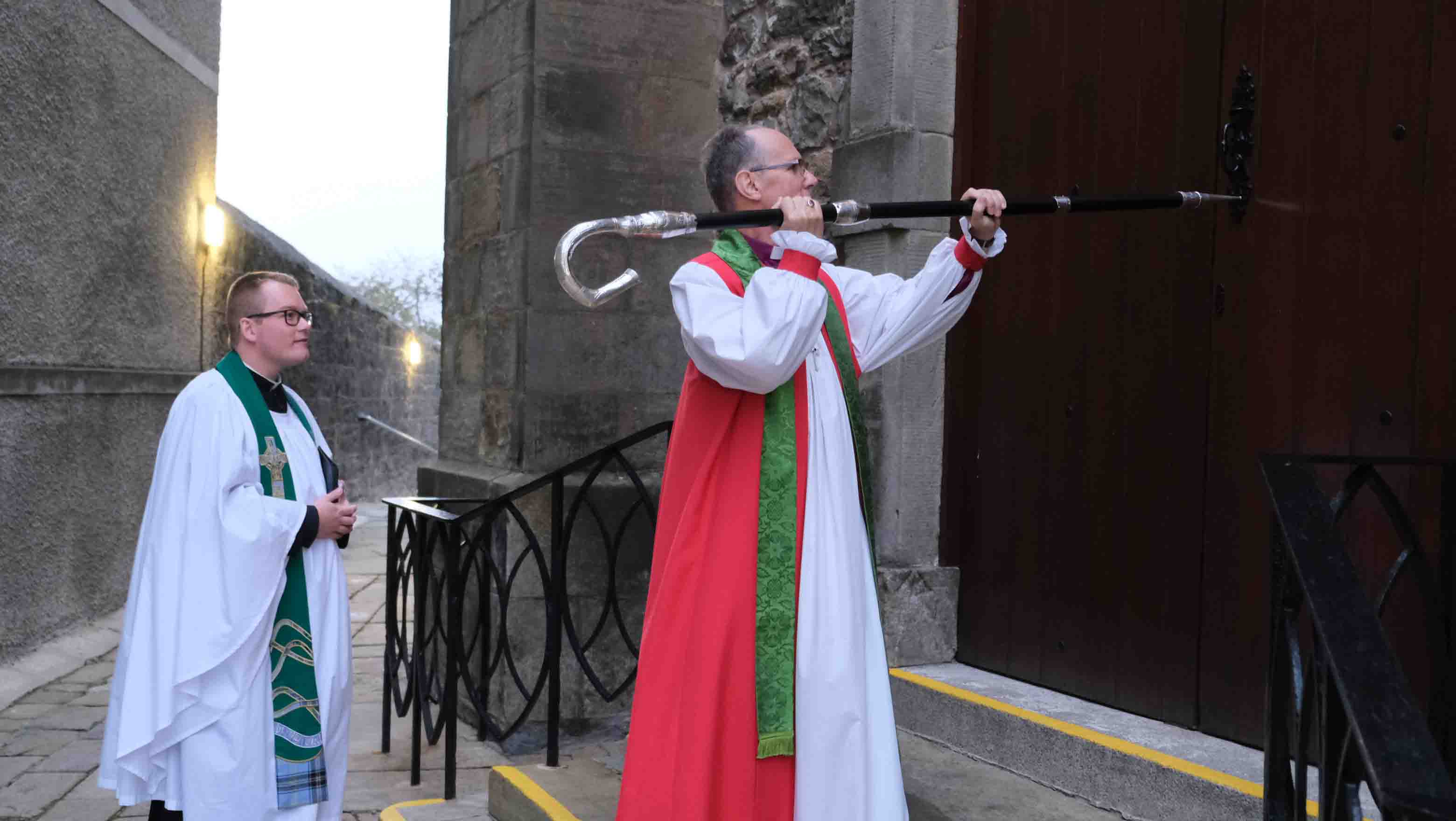 Bishop Ellis strikes the West Door of Enniskillen Cathedral at the start of his Service of Enthronment.