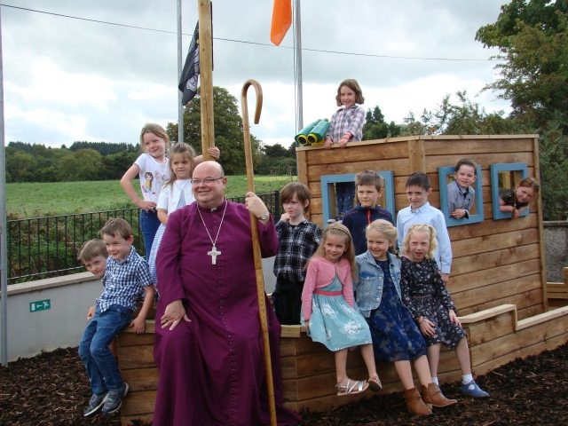 The younger children are joined at their Aistear Play boat by Bishop Colton.