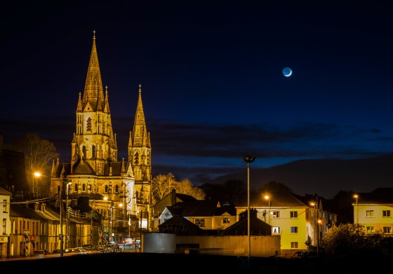 The crescent moon sets over St Fin Barre's Cathedral, Cork. Photograph © Cian O'Regan.