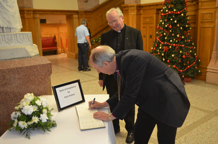 Bishops Good and McKeown signing the book of condolence for victims of the Paris attacks.