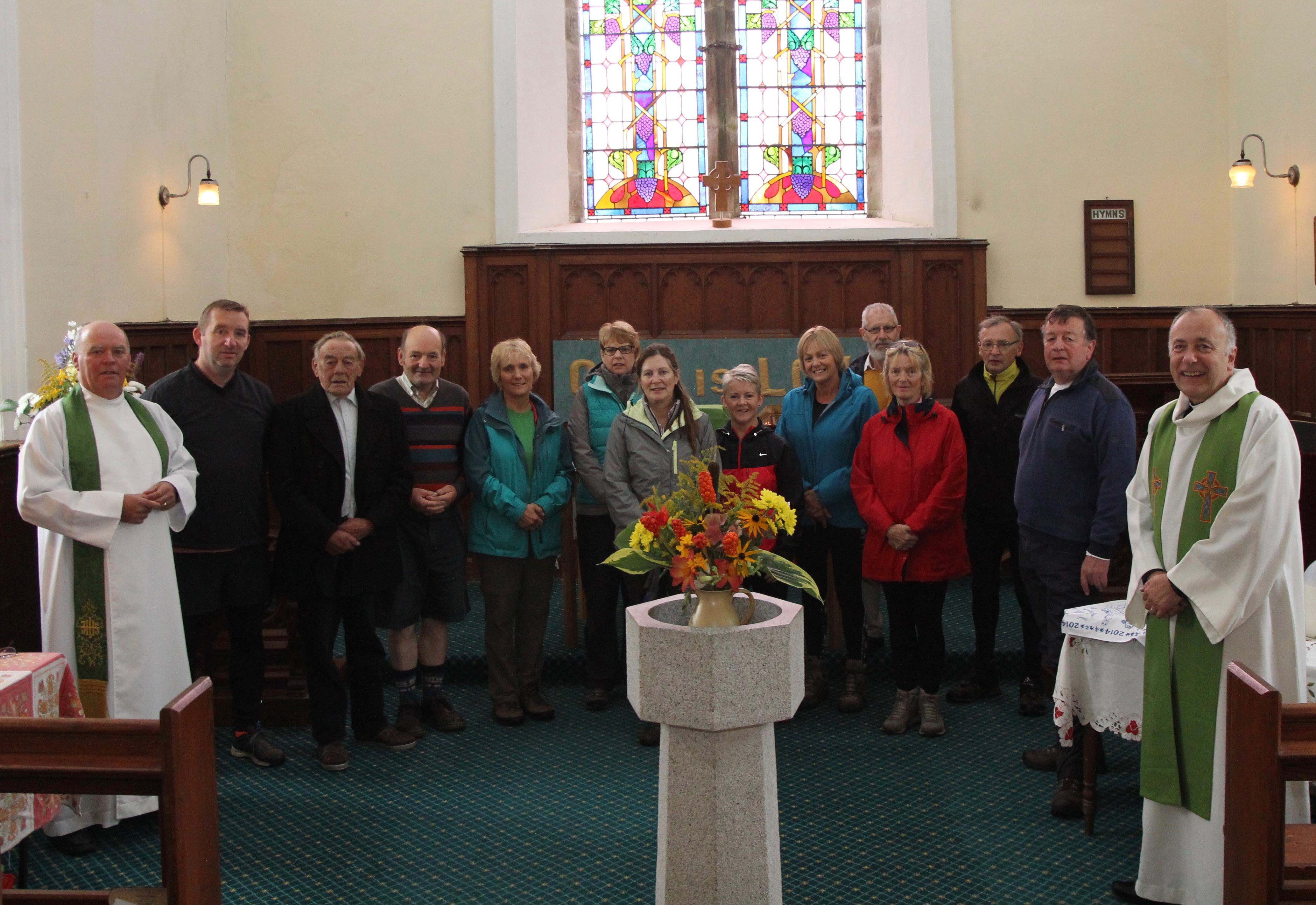 Participants in the Camino de Glendalough receiving their pilgrim blessing in St Kevin's Church, Hollywood.