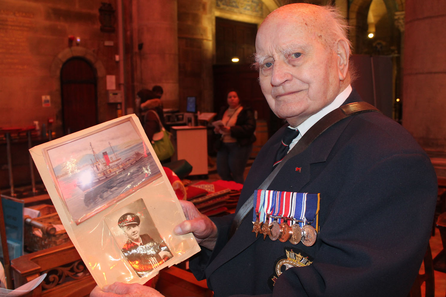 John Coulter, 95, with pictures of the Empire Meadow tug boat on which he served in 1953, and its Master.