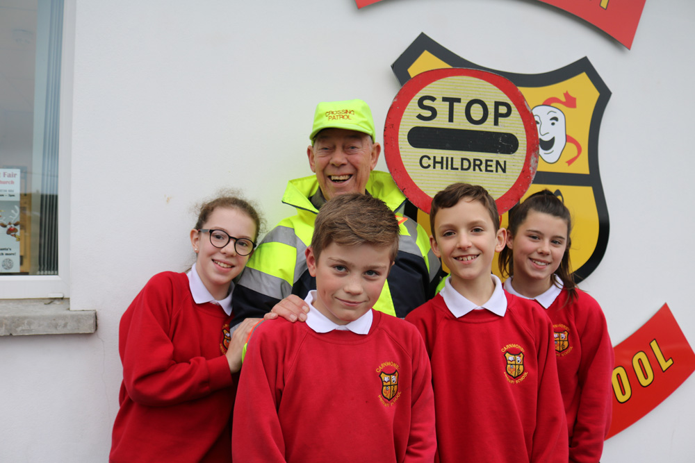 Lollipop man Ivan Gibson with some of the pupils at Carnmoney Primary School where he has worked for 26 years.