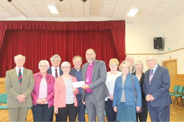 Bishop George Davison receiving a cheque from Aileen Gault, Coordinator of the recent exhibition.