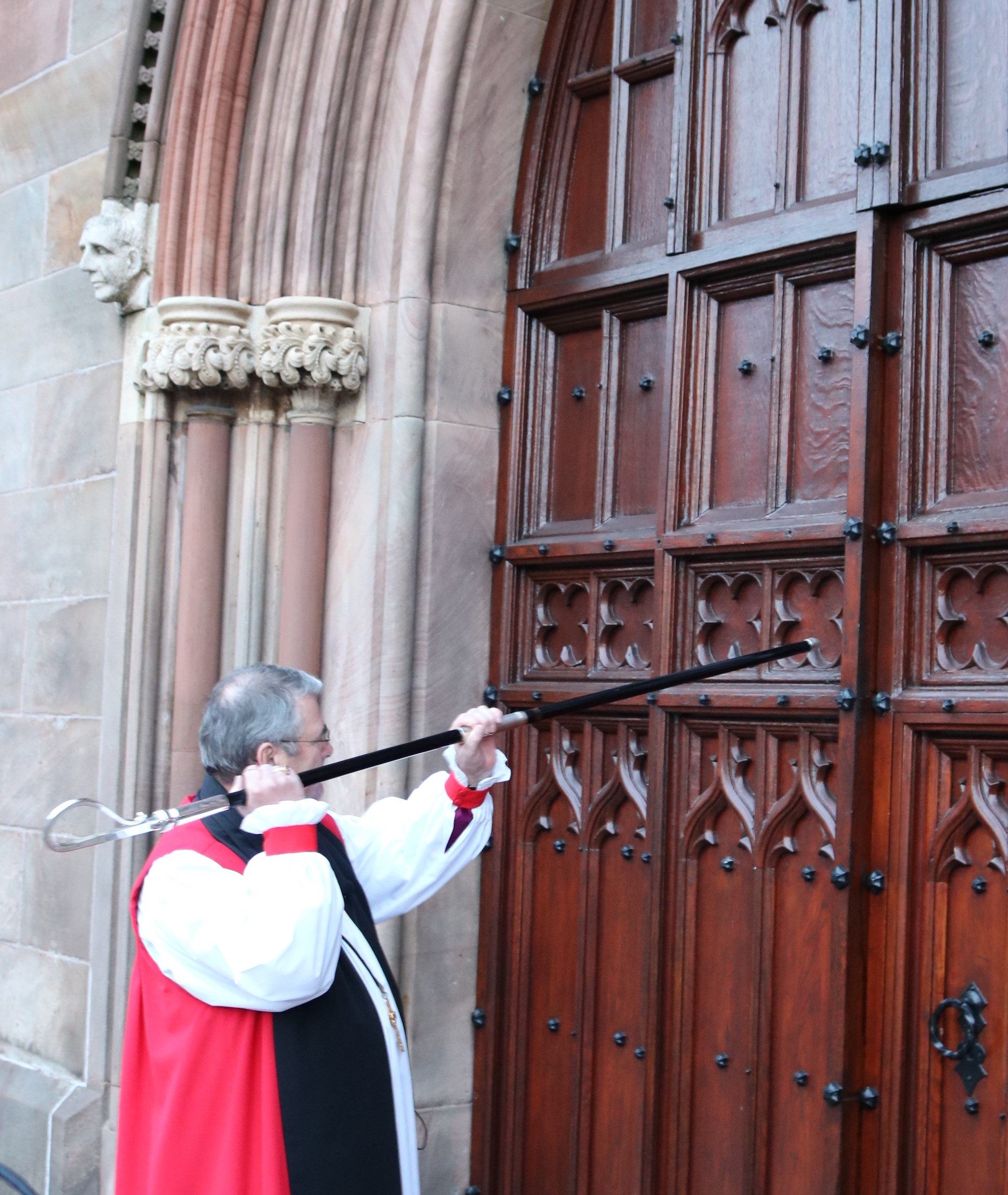 Archbishop John McDowell knocks on the door of St Patrick's Cathedral, Armagh, with his crozier before the Service of Enthronement.