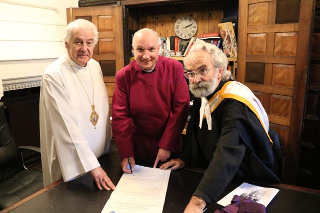 Bishop-elect Adrian Wilkinson signs the Episcopal Roll, accompanied by Archbishop Michael Jackson and the Revd Robert Marshall, Diocesan & Provincial Registrar.