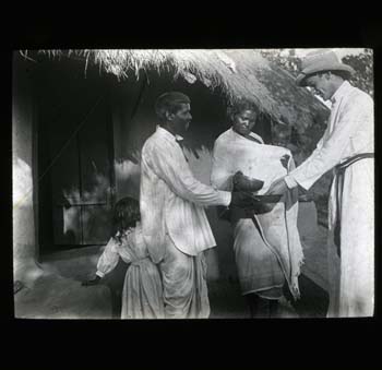 Couple welcoming the Revd Gerald Dickson (?) to their home by washing his hands